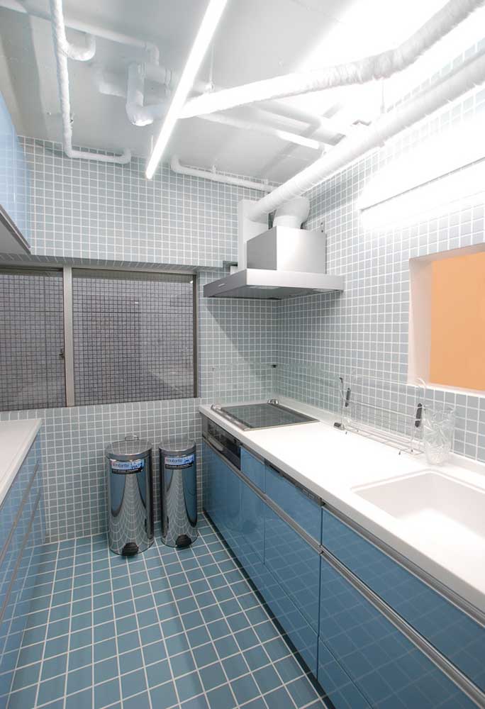 Cozinha decorada com ladrilhos azuis claros e armário planejado também em tom de azul