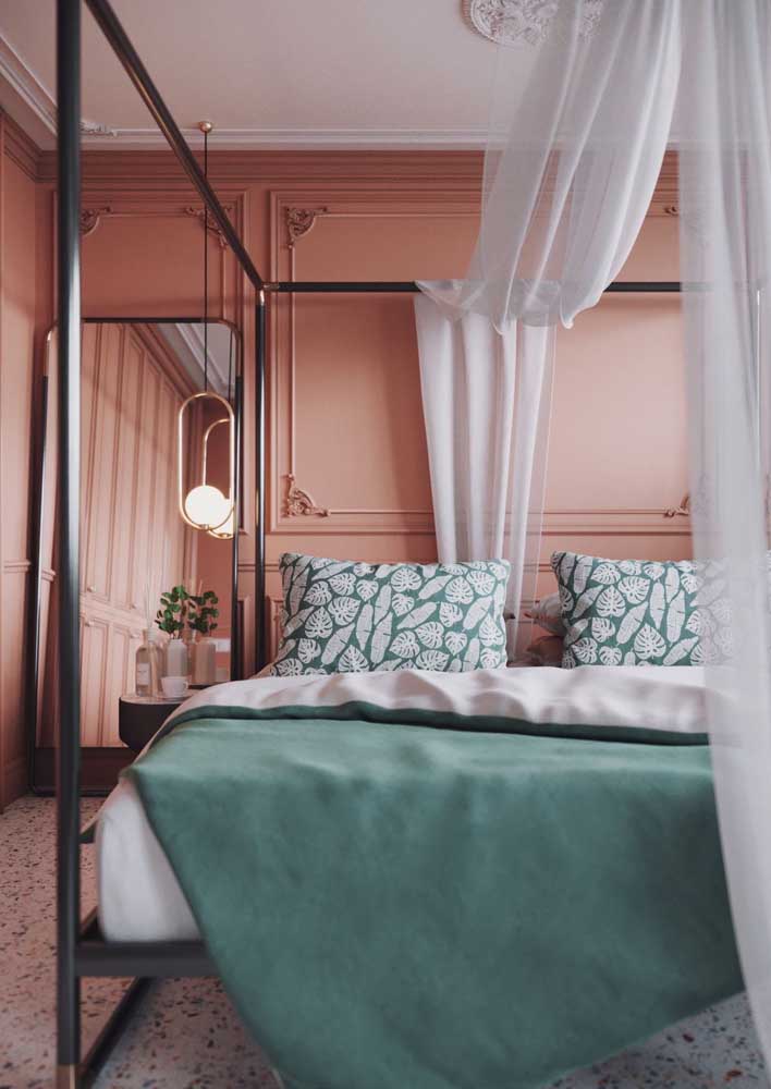 Quarto com parede cor coral. A proposta ficou ainda melhor com o detalhe da boiserie